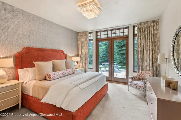 a bedroom with a bed and a large window