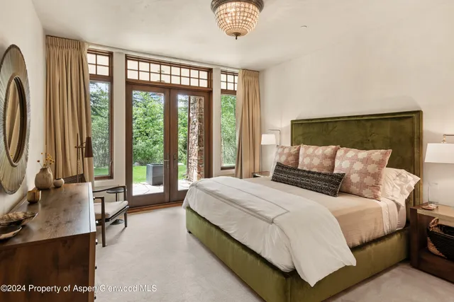 a bedroom with a bed couch and a large window