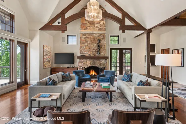 a living room with furniture chandelier and a fireplace