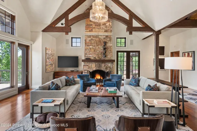 a living room with furniture chandelier and a fireplace