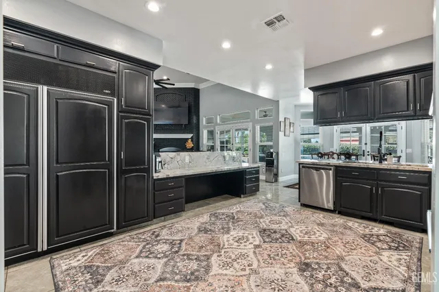 a kitchen with kitchen island granite countertop a stove sink cabinets and refrigerator