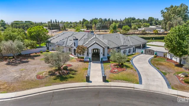 an aerial view of a house with a garden and lake view