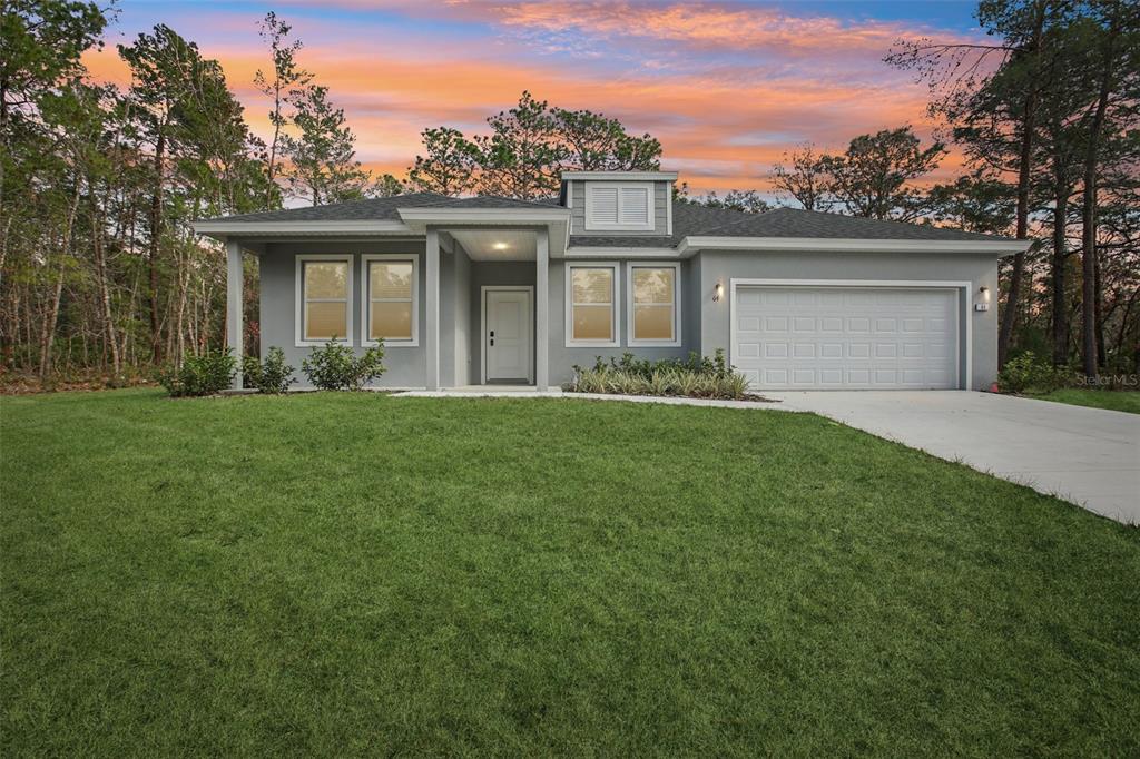 64 Cactus Street Homosassa, FL 34446 - Photo 1 of 12 a front view of a house with a yard and garage