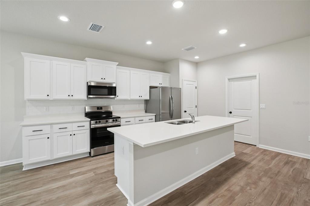 64 Cactus Street Homosassa, FL 34446 - Photo 7 of 12 a kitchen with stainless steel appliances a sink stove and refrigerator