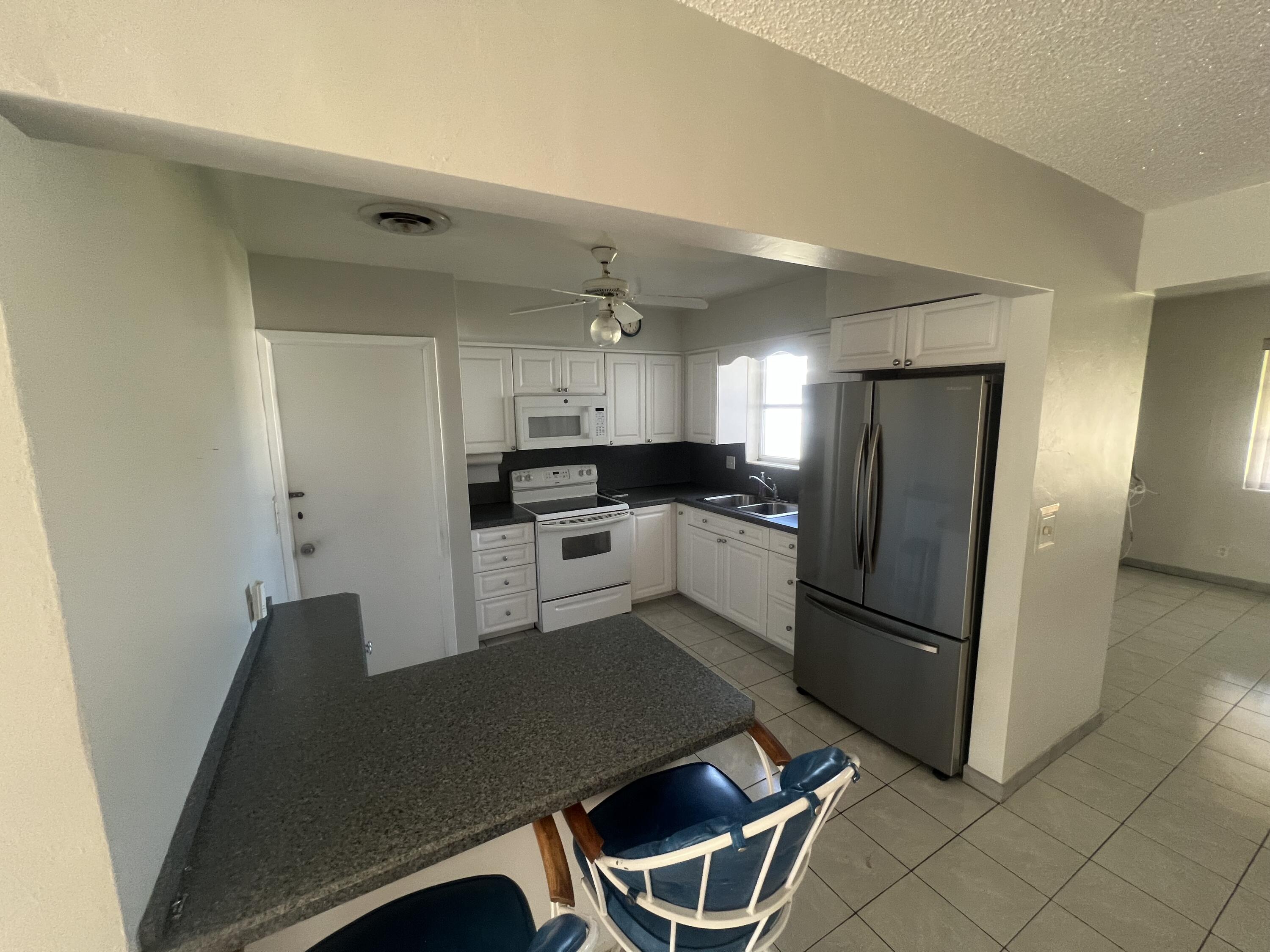 4007 Johnson Street Hollywood, FL 33021 - Photo 5 of 14 a kitchen with stainless steel appliances kitchen island granite countertop a refrigerator a stove a sink dishwasher and white countertops with wooden floor