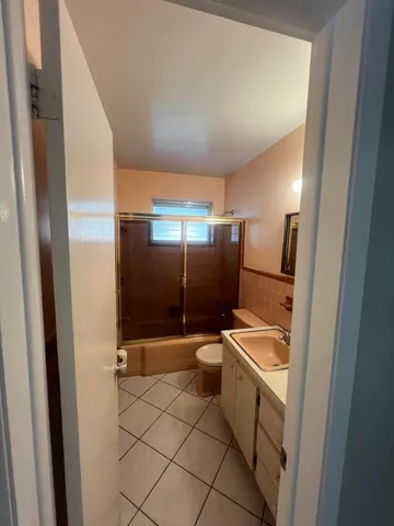 a bathroom with a sink a toilet a mirror and shower
