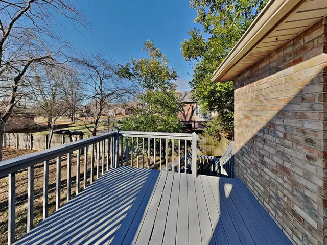 a balcony with wooden floor and stairs