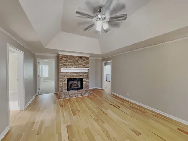 a view of an empty room with a fireplace and a window
