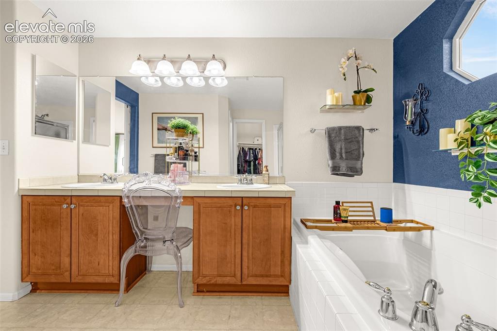 9127 Oakmont Road Peyton, CO 80831 - Photo 22 of 49 a bathroom with a tub sink and mirror