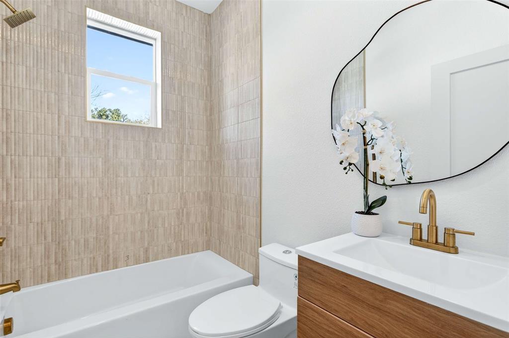 439 West 9th Street, Unit 5 Dallas, TX 75208 - Photo 14 of 28 a bathroom with a sink a toilet and a mirror