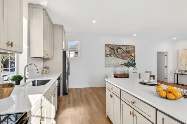 a kitchen with stainless steel appliances a sink a stove and wooden floor