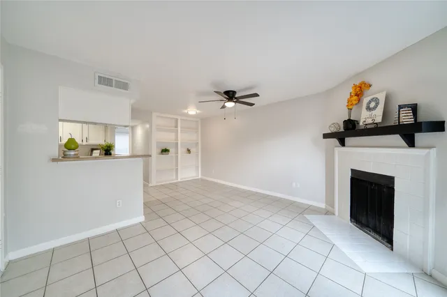 a view of an empty room and a kitchen