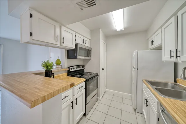 a kitchen with stainless steel appliances granite countertop a sink a stove a refrigerator a microwave and cabinets