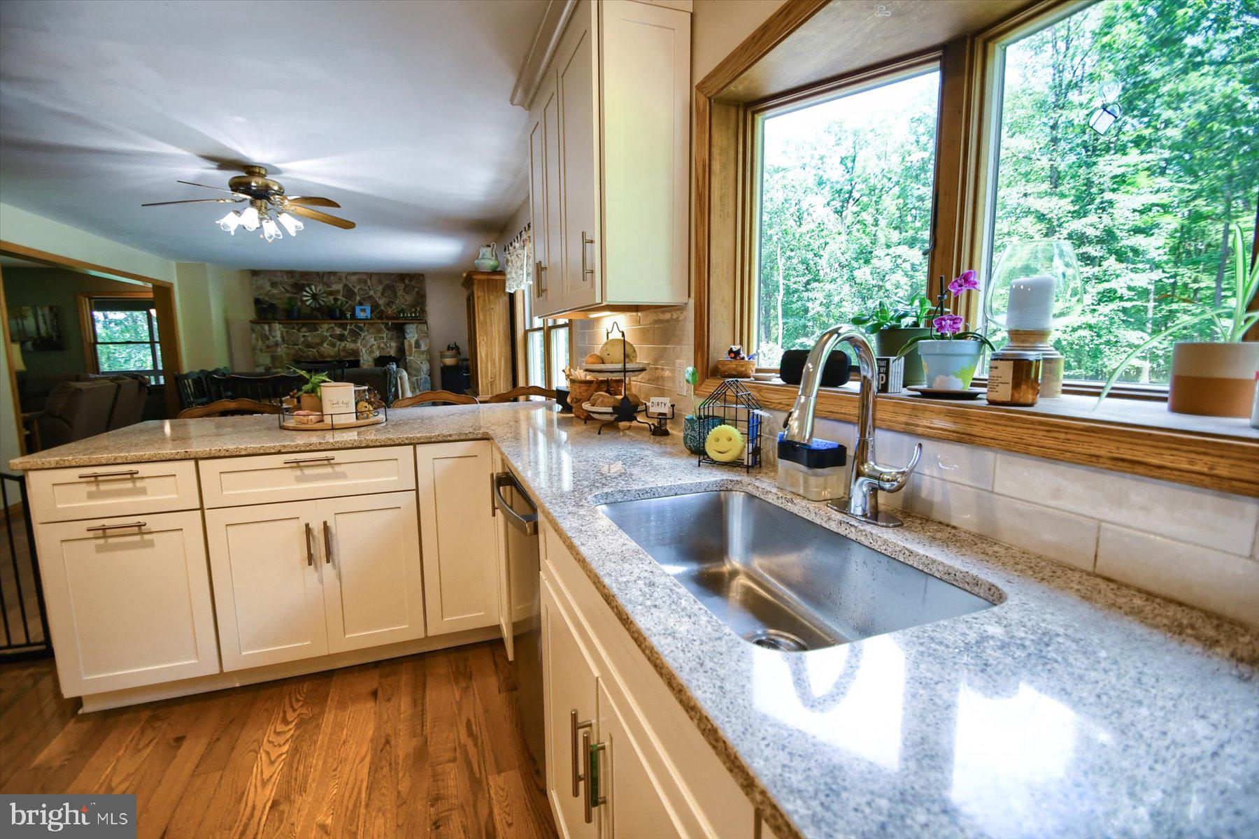 3700 Lehnenberg Road Riegelsville, PA 18077 - Photo 39 of 48 a kitchen with granite countertop a sink and white cabinets with wooden floor