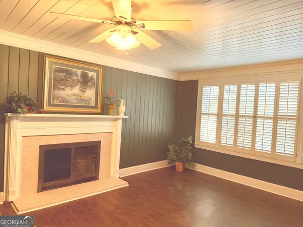 an empty room with windows and fireplace