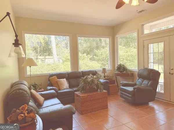 a living room with furniture and floor to ceiling windows