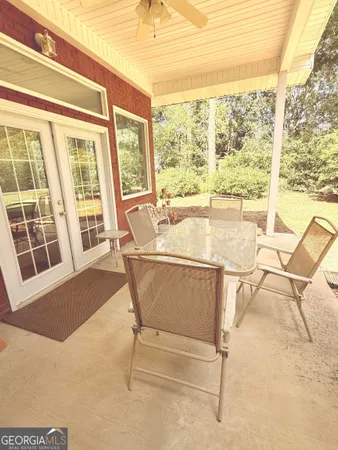 a dining room with furniture and large windows