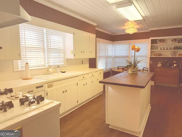 a utility room with a sink a window and cabinets