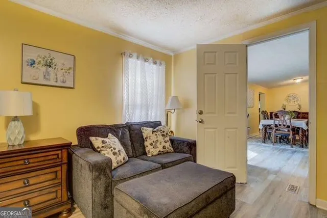 a living room with couches and piano table with wooden floor