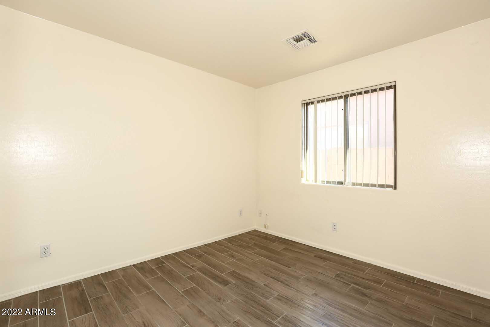 4319 West Carson Road Laveen, AZ 85339 - Photo 23 of 36 an empty room with wooden floor and windows