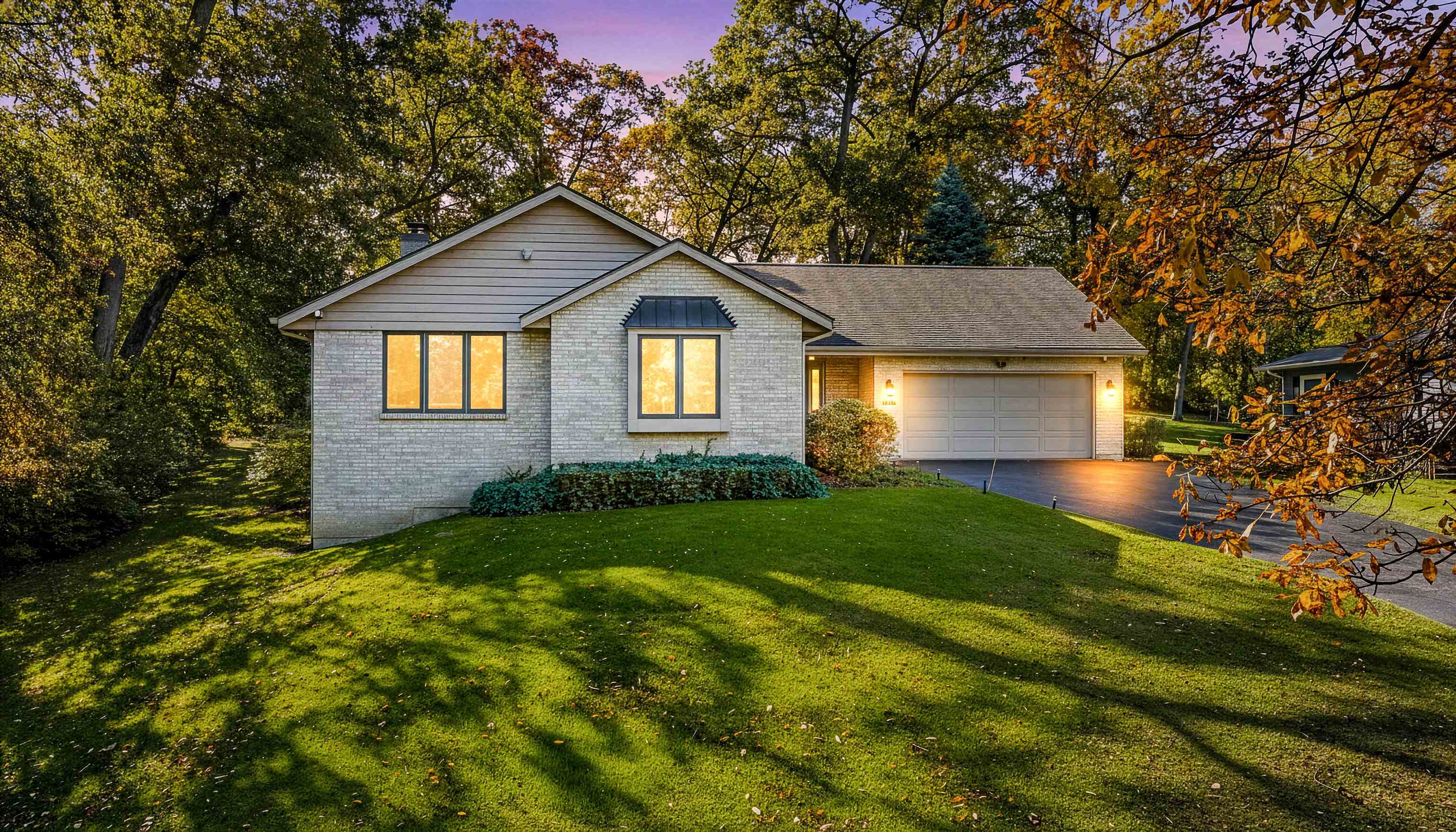 a front view of a house with yard and green space