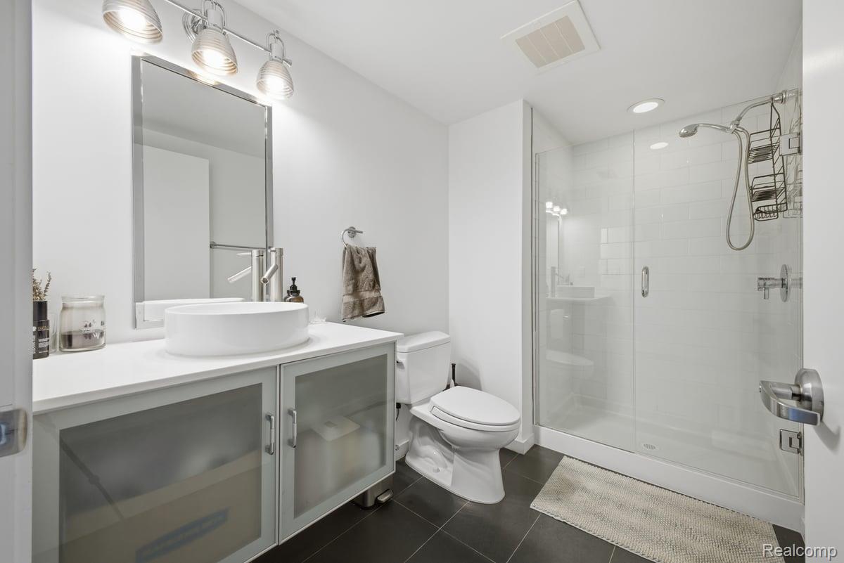 211 East 9 Mile Road, Unit 313 Ferndale, MI 48220 - Photo 27 of 40 Bathroom featuring vanity, a shower stall, dark tile patterned flooring, and recessed lighting
