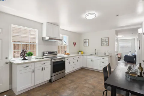 a kitchen with granite countertop a sink a stove and cabinets