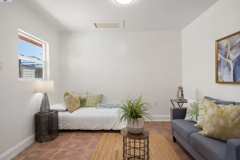 a view of a bedroom with furniture and window