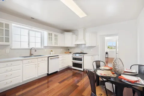 a kitchen with granite countertop white cabinets and white appliances
