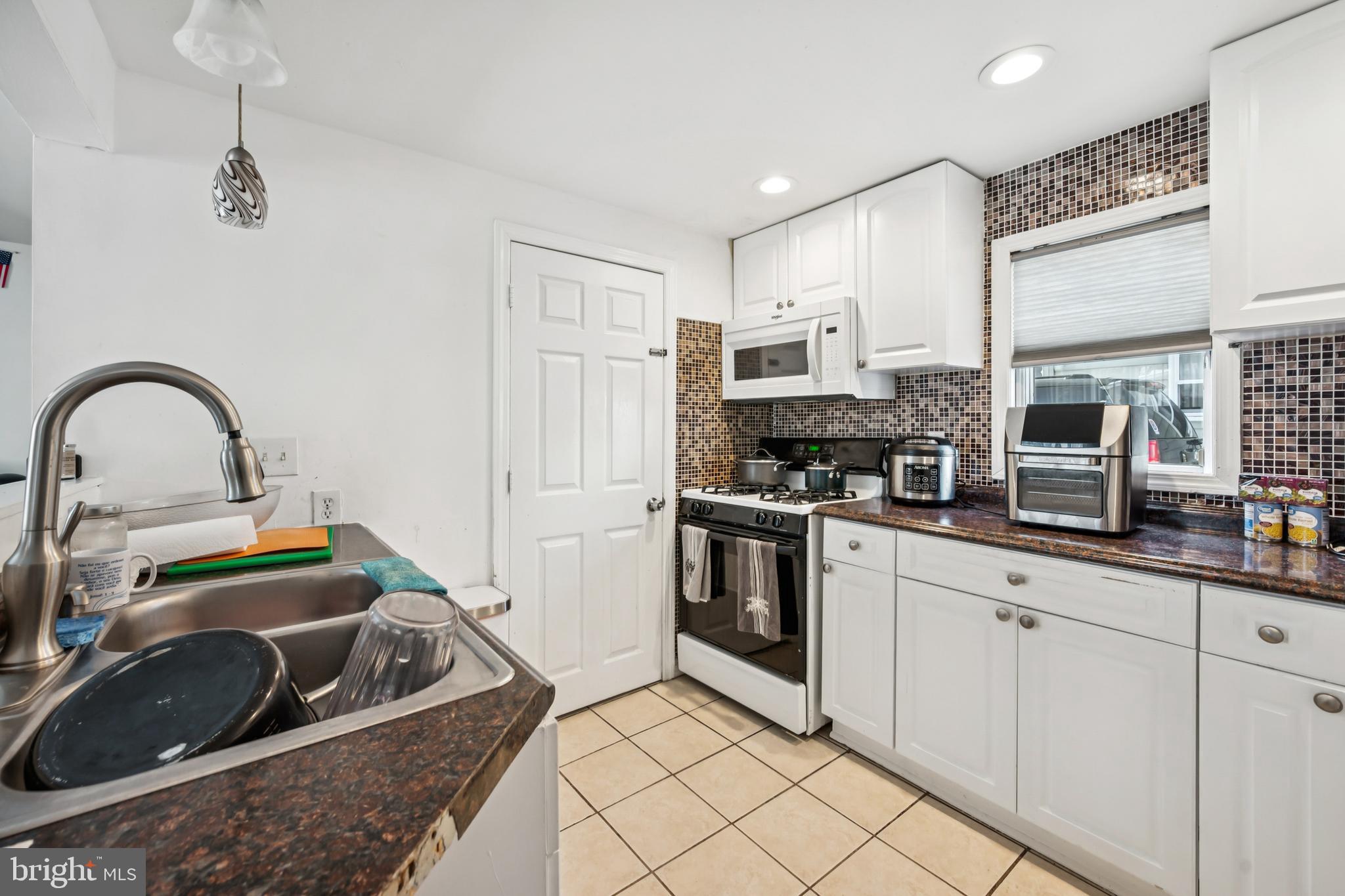 640 Bem Street Riverside, NJ 08075 - Photo 6 of 26 a kitchen with white cabinets a sink and appliances