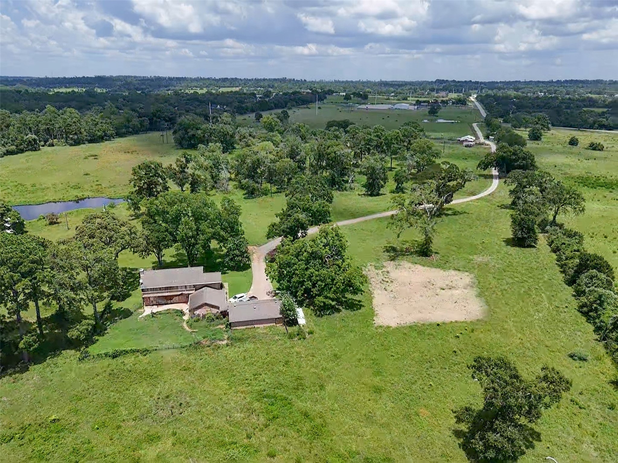 6605 Spring Branch Road Montgomery, TX 77316 - Photo 8 of 12 A fenced green space behind the main residence provides a secure area for pets or a future garden, framed by wide pastures and sky-high pines.