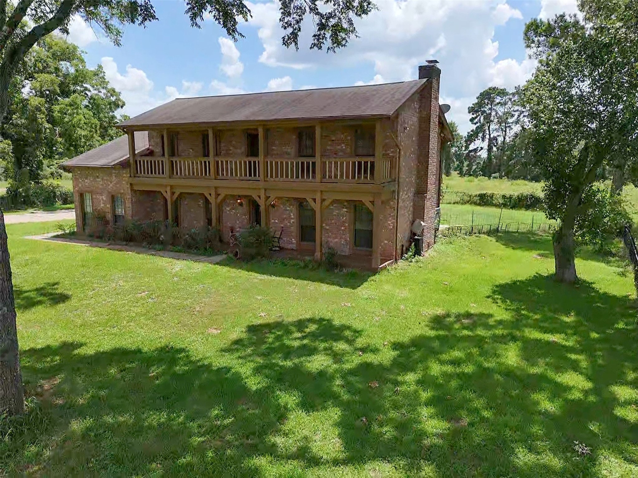 6605 Spring Branch Road Montgomery, TX 77316 - Photo 10 of 12 The main residence sits proudly shaded by towering hardwoods, offering stunning curb appeal and a sense of timeless Southern charm.