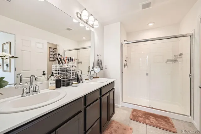 a bathroom with a double vanity sink mirror and shower