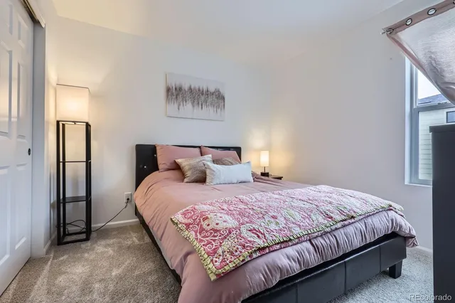 a bedroom with a bed and a painting on the wall