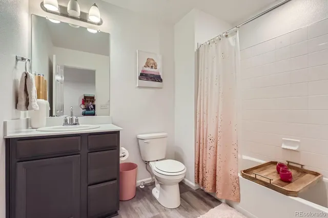 a bathroom with a toilet sink vanity and mirror