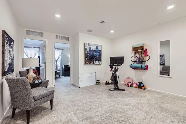 a view of a livingroom with furniture and gym equipment
