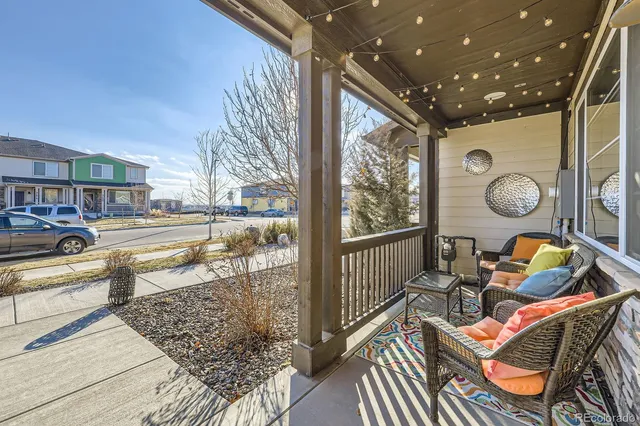 a living room with couches a large dining table and a fireplace with wooden floor