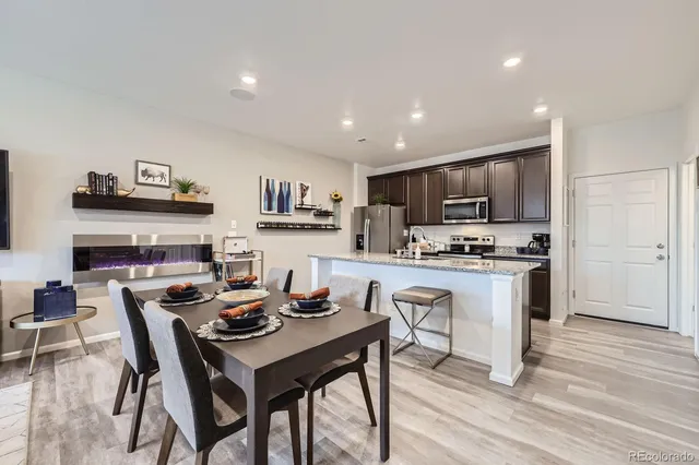 a kitchen with a dining table chairs refrigerator and cabinets