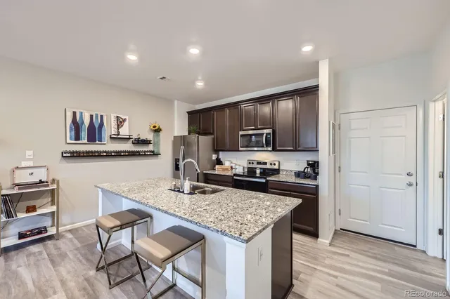 a kitchen with granite countertop kitchen island cabinets and wooden floor