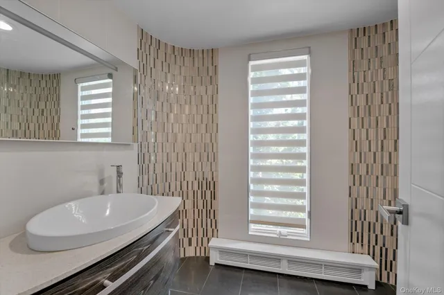 a bathroom with a sink a toilet and a window