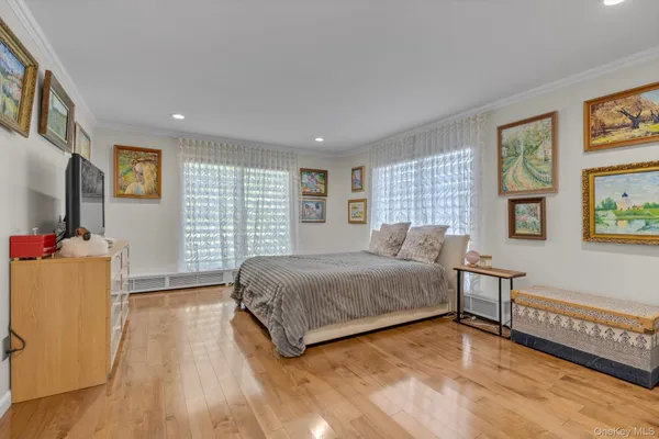 a spacious bedroom with a bed and a flat screen tv