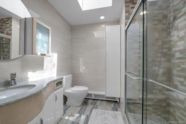 a bathroom with a granite countertop sink toilet and shower
