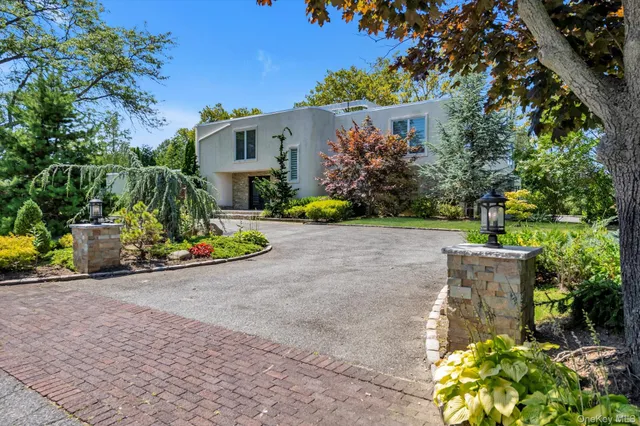 a view of a house with potted plants and large trees
