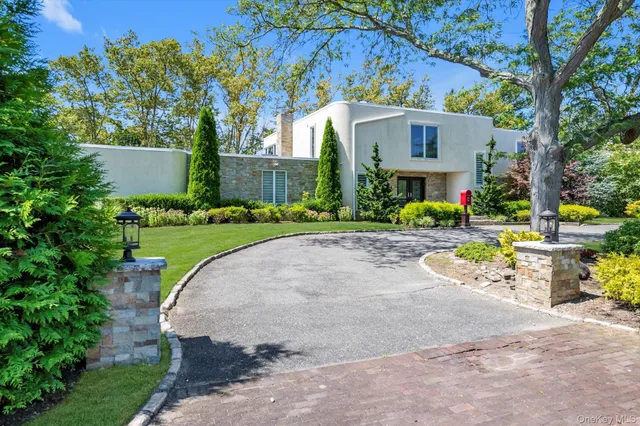a view of a house with a yard and table and chairs under an umbrella