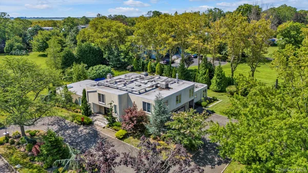 a view of a house with a big yard and large trees