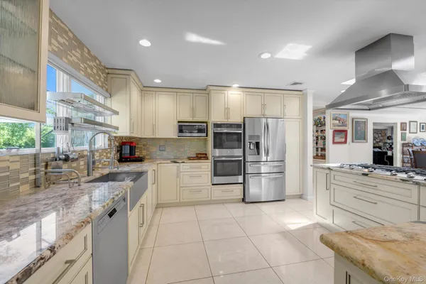 a kitchen with stainless steel appliances granite countertop a refrigerator and a stove top oven