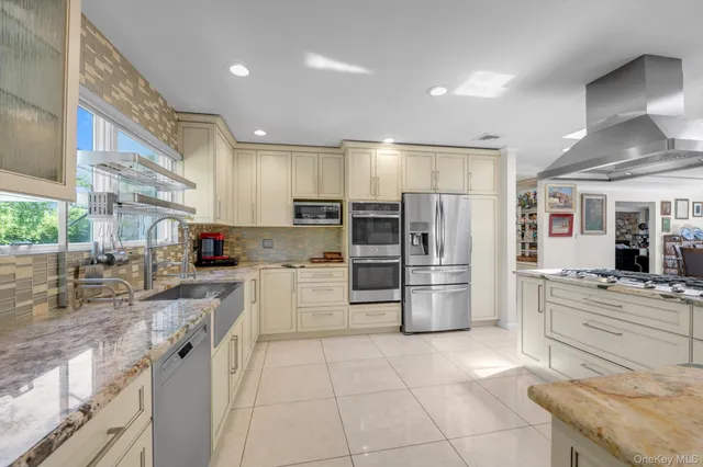a kitchen with stainless steel appliances granite countertop a refrigerator and a stove top oven