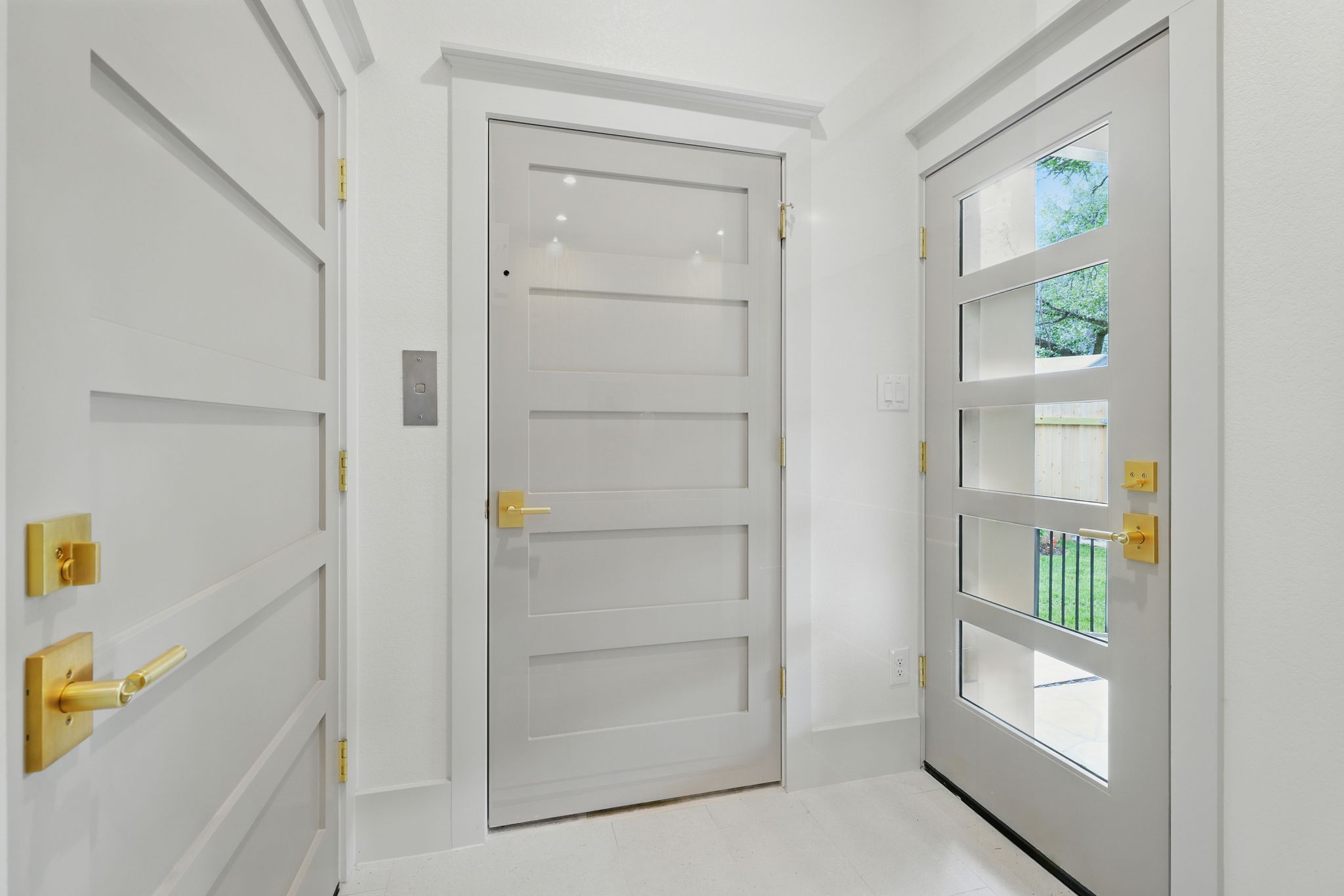 6905 Rudi Cove Austin, TX 78759 - Photo 17 of 37 Clean lines and a luminous entry, featuring three doors with stylish brass hardware, invite residents inside.