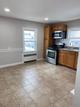 a large kitchen with stainless steel appliances granite countertop a stove a sink and a granite counter tops