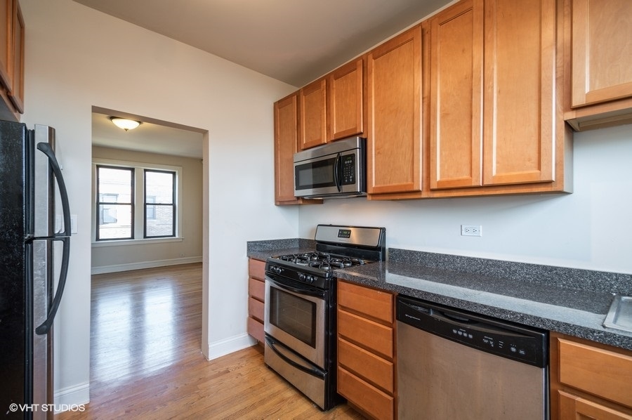 Undisclosed Address Chicago, IL 60657 - Photo 2 of 7 a kitchen with stainless steel appliances granite countertop a stove a sink and a microwave